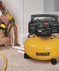 Heavy Duty 18 Gauge Brad Nailer And 6 Gallon Oil Free Pancake Air Compressor Combo Kit with yellow compressor in use.