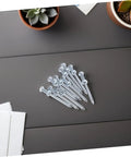 Heavy Duty Lawn Aerator Shoes With Replaceable Metal Spikes 12 Pack shown in a set of metal spikes on a table