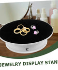 Premium Rotating Jewelry Display Stand With Smooth Electric Turntable Spin For Selling Accessories And Cosmetics features rings on a black velvet top.