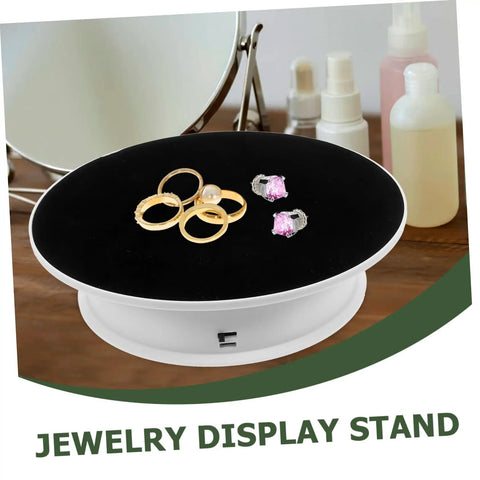 Premium Rotating Jewelry Display Stand With Smooth Electric Turntable Spin For Selling Accessories And Cosmetics features rings on a black velvet top.
