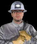 Intrinsically Safe LED IP67 Headlamp for Hazardous Areas attaches to hard hats, worn by worker with wrench and safety gear.