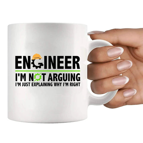 A white 11 oz ceramic mug held by a hand with text 'Engineer I'm Not Arguing I'm Just Explaining Why I'm Right'.