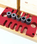 Heavy Duty 3 In 1 Drill Guide Block for Woodworking with aluminum alloy hole locator and dowel jig on wooden plank.