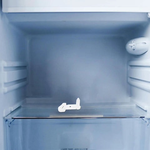 Heavy Duty Plastic Freezer Door Stop For Fridge Repair on fridge shelf, durable white material designed for easy DIY installation.