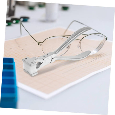 Eyeglass Adjustment Pliers for Nose Pad Screws Quick Fix Tool placed on sheet with eyeglasses in background
