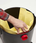 Hand placing 15-22 Gallon Wet Dry Shop Vac Dust Bag for dry debris cleanup, fits Shop Vac brand vacs, captures fine dust and drywall dust.