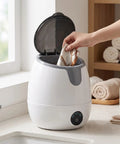 Person placing a cloth into the Compact Mini Countertop Washer With Spinning Dehydration Basket And Sanitary Blue Light Mode For Undies Socks And Baby Clothes Delivers Big Time Fresh Results While Making Laundry Day Hella Easy And Completely Hassle Free.