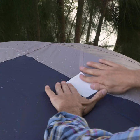Applying Mini White Rubberized Waterproof Tape for Leak Sealing and Patch Jobs on outdoor tent with hands showing usage.