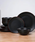 Venus 12 Piece Stoneware Plates And Bowls Set With Trim Chip Resistant Dinnerware For Four Matte Black displayed on wooden table