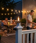 Evening deck scene with built-in torch holder for tiki torches, man grilling, family dining, and ambient lighting.