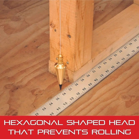 Beefy Solid Steel Plumb Bob With Braided Nylon Line for Layout Construction, hexagonal head prevents rolling, on wooden floor and ruler.