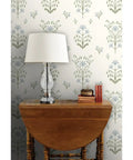 Premium Floral Meadow Wallcovering With A Subtle Matte Linen Texture Hits Different Across Every Room Built Tough For Busy Households Featuring No Sweat Paste To Paper Install on a living room wall with lamp and books.