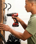 Person using Two Tool Cordless Drill And Right Angle Impact Kit With 12V Brushless Power, Half Inch Drill Driver on wall hook