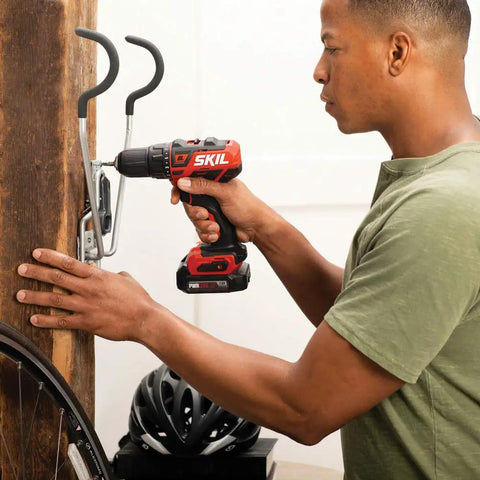 Person using Two Tool Cordless Drill And Right Angle Impact Kit With 12V Brushless Power, Half Inch Drill Driver on wall hook