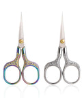 Two-piece set of small embroidery scissors with ornate handles; rainbow-colored left pair and silver right pair.