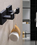 Matte Black Stainless Steel Wall Hooks Two Pack Heavy Duty Coat and Towel Hangers for Bathroom and Kitchen Square Modern Mount Rustproof and Durable Perfect for Coats Towels Bags Hats holding a bath brush