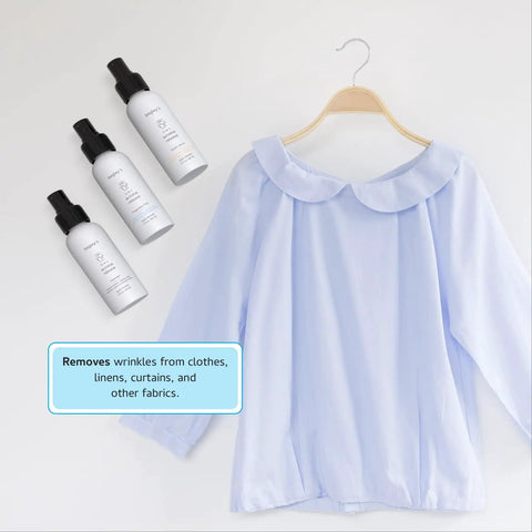 3-In-1 No Iron Wrinkle Release, Static Cling Remover, Odor Eliminator And Fabric Refresher Spray next to a blue blouse on hanger