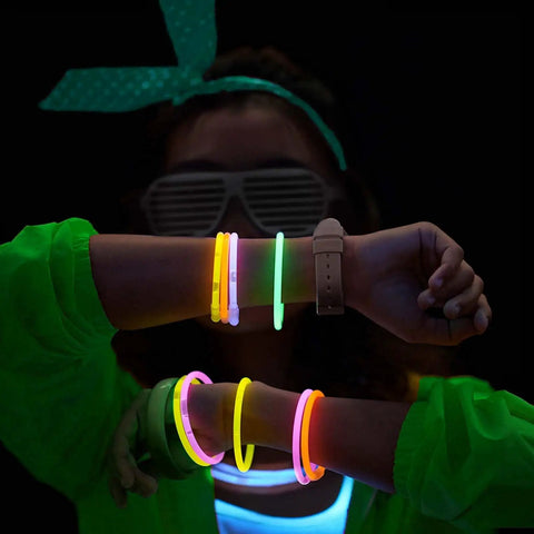 Person wearing 100 Count Glow Sticks Bulk Party Pack with 8 Inch Glow Bracelets and Connectors in assorted colors, glowing in the dark.