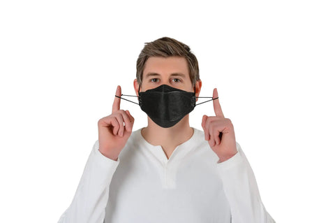 Man wearing 11 Piece Black KF94 Protective Face Masks for Adults with 4 Layer Filter and 3D Design, adjusting ear straps