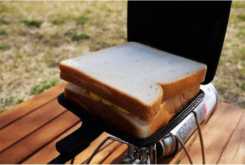 Sandwich cooking in Cast Iron Camp Pie Cooker Set Of 2 For Campfire Sandwiches And Pies, pre-seasoned square pie iron on open flame.