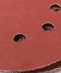 Close-up of 5-inch 8-hole hook and loop sanding disc showing aluminum oxide grit for grinding tasks. Grab These 60-Piece 5-Inch 8-Hole Hook And Loop Sanding Discs With Aluminum Oxide Grit For Stone Glass Metal Wood And Angle Grinder Polishing Tasks That Stay Cool And Don't Clog Up The Job.