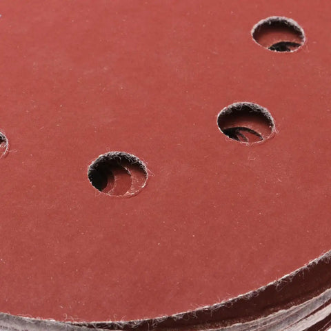 Close-up of 5-inch 8-hole hook and loop sanding disc showing aluminum oxide grit for grinding tasks. Grab These 60-Piece 5-Inch 8-Hole Hook And Loop Sanding Discs With Aluminum Oxide Grit For Stone Glass Metal Wood And Angle Grinder Polishing Tasks That Stay Cool And Don't Clog Up The Job.