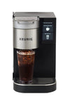 Front view of Plumbed Single Serve Office Coffee Maker With 150 Plus K Cup Varieties Brews Coffee Tea And Hot Cocoa In About A Minute Five Cup Sizes From 4 To 12 Oz Travel Mug Compatible Perfect For Busy Office Bosses, in use with a filled travel mug.