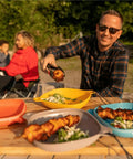 Person serving food into the Six Piece Camping Mess Kit With Plate Bowl Cup Switch Spork Utensil Set And Tether.