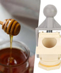 Ergonomic Honey Gate Valve with Ball Handle Plastic Tap beside honey dipper pouring into jar.