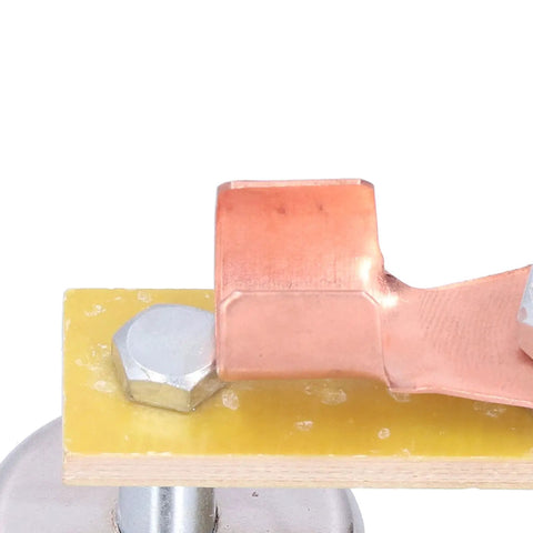 Heavy Duty Magnetic Welding Support With Strong Copper Tail Clamp Grounding Tool For Mechanical Repair And Metal Fixtures Featuring Easy Grip Screw Design close-up of copper tail clamp on insulation board.