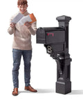 Person standing beside Atherton Mail Post For Side And Undermount Mailboxes, Onyx Black Finish, weather-resistant outdoor post.