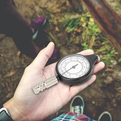 Person holding Handy Mini Map Measurer For Hiking And Travel, Old School Rolling Distance Tool With A Metal Wheel, outdoors