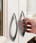 Hand installing a 10 Pack Brushed Nickel Cabinet Pulls 5 Inch Arch Twisted Silver Handles for drawers in a modern kitchen