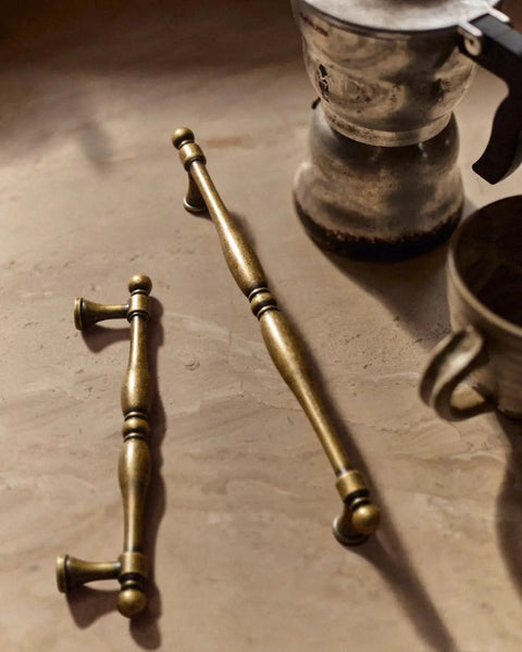 Six Pack Antique Brass Cabinet Pulls With 7.6 Inch Hole Center on table next to vintage coffee pot
