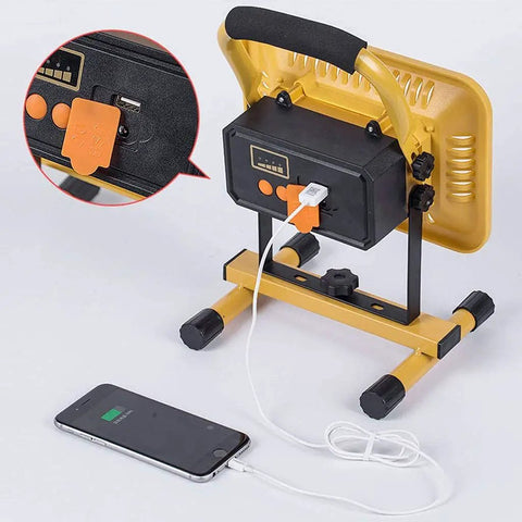 JUDYSSY Home Floodlight with USB charging port, adjustable stand, showing connection to a smartphone for emergency use.