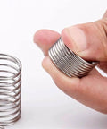 Hand holding Extension Compression Springs Kit, 10 Piece Set With Wire Diameters From 0.3 To 1.2 Mm, Outer Diameter 5 Mm, 50 Mm Length, 304 Stainless