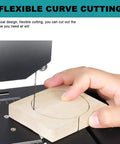 Hand using 800W Vertical Bench Saw For Wood And Foam with Scroll Cutting on wood piece, flexible curve cutting showcased.