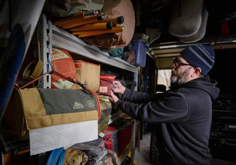 Man organizing shelves with Spill Ender 3 In 1 Paper Towel Holder For Cars And Campsites hanging, waterproof and compact.