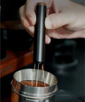No Fuss WDT Needle Tool For Espresso Brewing retractable telestopic stirrer leveling coffee grounds in a portafilter basket.