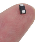 Small AC to DC rectifier diode on fingertip, part of Top Shelf Rectifier Diode 100 Piece Assortment Kit Heavy Duty Modules.