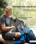 Man packing 40W Foldable Solar Panel Charger With USB C And DC5521 Output IP65 Waterproof Monocrystalline Cells Ultra Portable into backpack while camping
