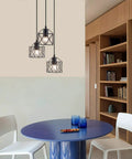Industrial 3-Light Pendant Light With Black Metal Cage Shade hanging over modern dining area with round table