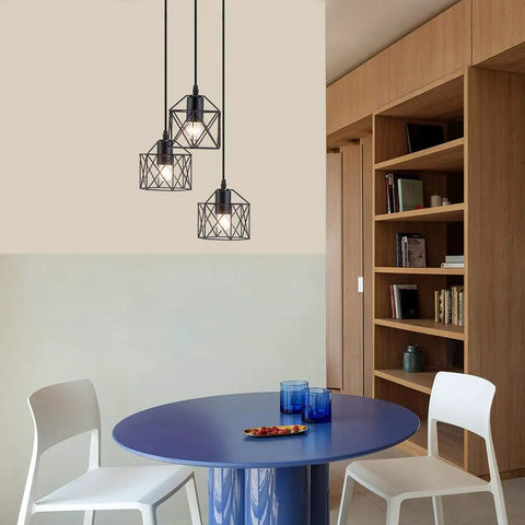 Industrial 3-Light Pendant Light With Black Metal Cage Shade hanging over modern dining area with round table