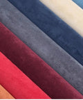 Colorful suede fabric rolls including red, grey, blue, and beige, showcasing textured upholstery material.
