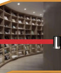 Heavy Duty Wall Mounted Retractable Belt Barrier With Magnetic Snap And Nine Foot Red Stanchion Rope for crowd control in library setting.