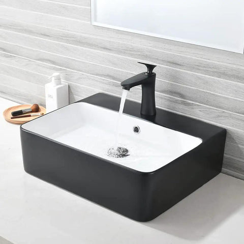 Matte Black Vessel Sink And Faucet Combo For Modern Bathrooms 18x16 Inch Rectangular Above Counter Porcelain Ceramic Vanity Sink With Dual Faucets Pop Up Drain And Water Lines installed on white countertop with water running.