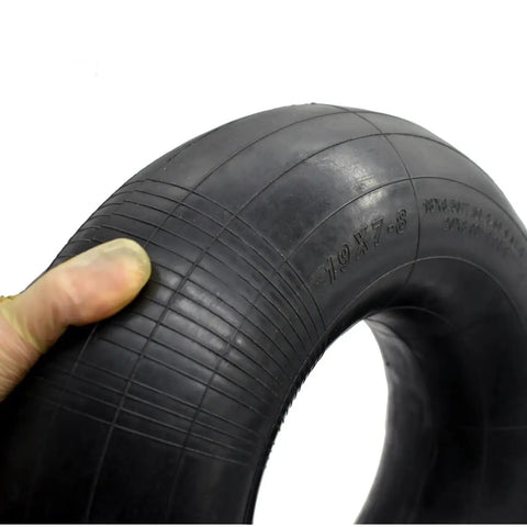 Close-up of a 19x7-8 Inner Tube With TR13 Straight Valve Stem for ATV and equipment use, held by a gloved hand.