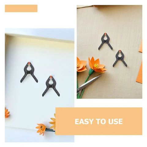 Top Tier Heavy Duty Spring Clamps Set For Woodworking And Photography Backdrops, Elastic Plastic Clips With Compact Design Great For Any Creative Project. Black plastic spring clamps holding paper backdrop and craft flowers