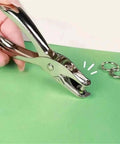 Hand using Metal Handheld Hole Puncher With 3Mm And 6Mm Circular Holes, Punches Up To 8 Sheets Of A4 Paper, Durable Steel Build