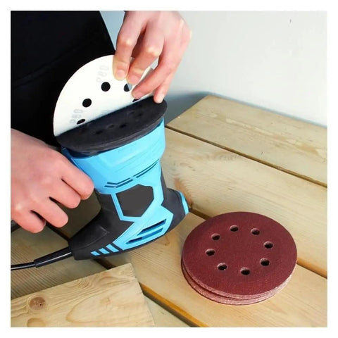 User changing 5 inch sanding disc on a blue electric sander, showcasing 8-hole hook and loop design for smooth finish.